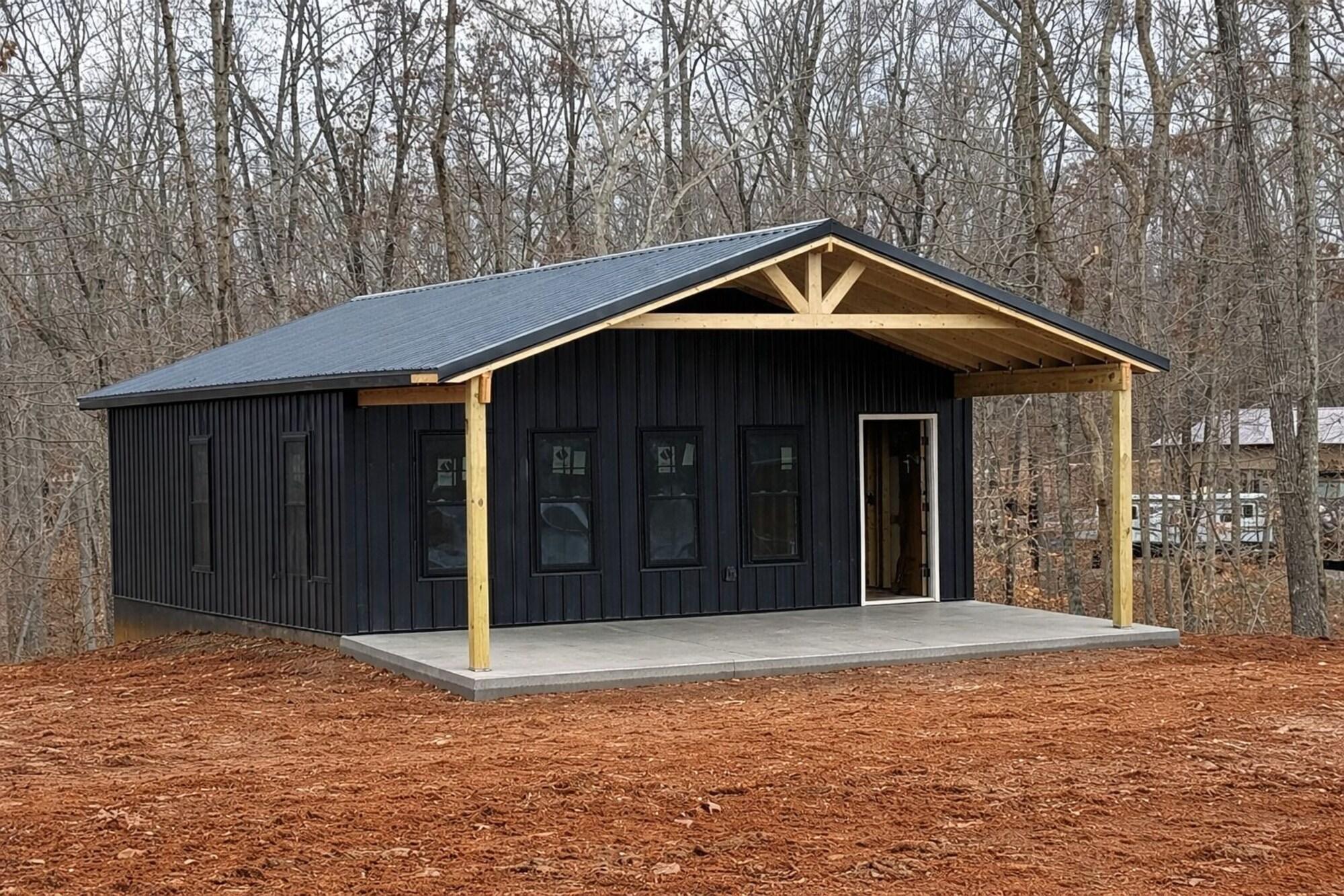 Hideaway at Wolf Creek modern black studio cabin with covered porch in the woods near Wolf Creek Marina