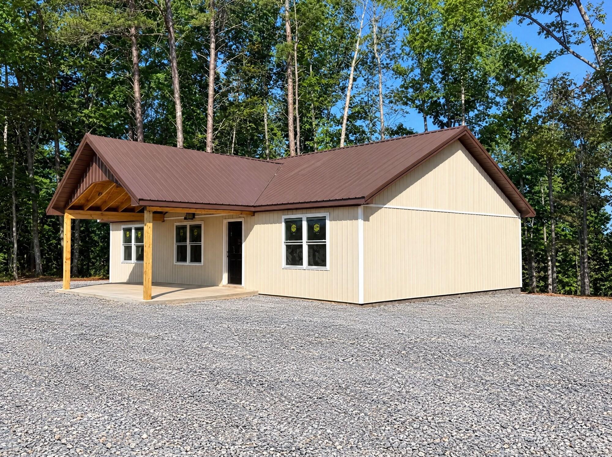 Lake Daze Retreat cabin exterior with covered front porch and gravel parking for boats and trailers